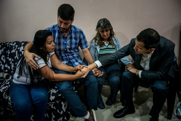 Roberto Patiño, second from left, and the opposition leader Juan Guaidó comforting the family of a man killed in an antigovernment protest last year.
