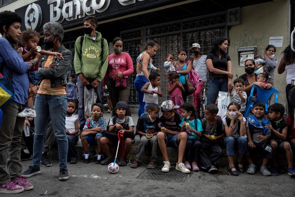 Un grupo de personas hacen fila para recibir donativos en una calle de Caracas, el 6 de enero de 2021.