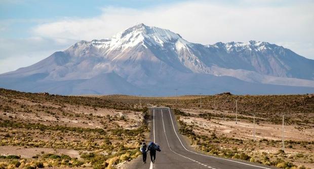 Venezuelan migrants trudge along an exposed road on the altiplano in northern Chile having crossed ...
