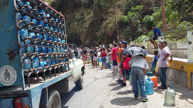Water shortages in Caracas continue to force residents of poor neighbourhoods to form long lines to fill a few jerry cans at roadside standpipes. Bottled water is becoming increasingly expensive in the midst of Venezuela's deep socioeconomic crisis. CREDIT: Humberto Márquez /IPS