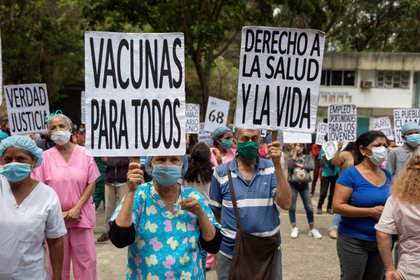 Trabajadores de la salud sostienen carteles durante una manifestación por el Día de los trabajadores en Caracas (EFE/RAYNER PEÑA R./Archivo)