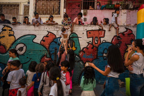 Children lining up in El Cementerio, a community in Caracas, to play in an inflatable bouncy castle set up by the armed gang in charge of the area.